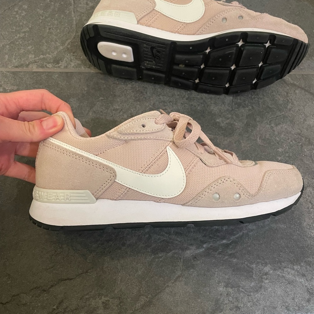 Nike dusty pink colored women’s tennis shoes.